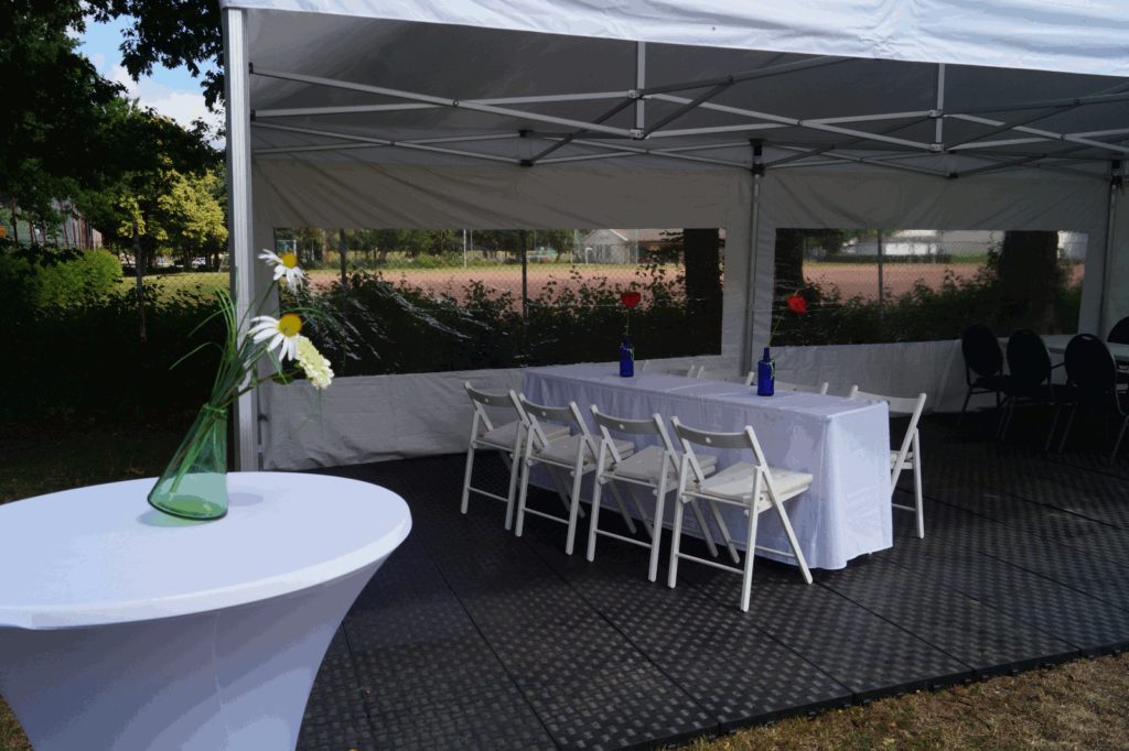 Zelt mit anthrazitfarbenem Kunststoffboden und langer Tafel